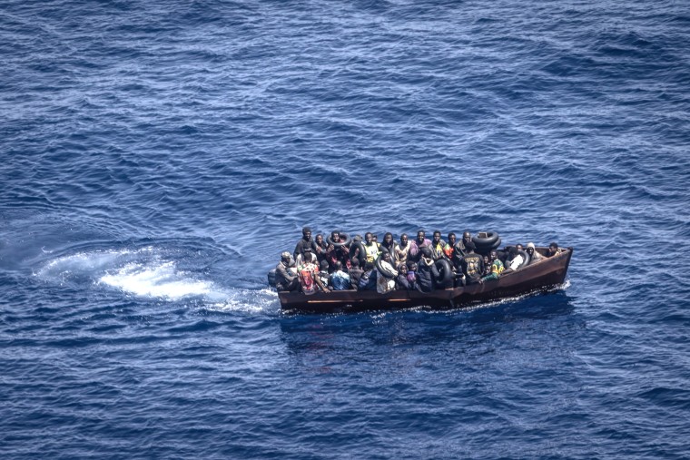 Migrants steer a boat from the northern coast of Africa across the Mediterranean Sea towards the Italian island of Lampedusa
