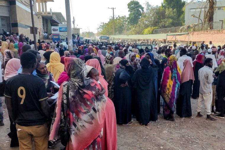 People from states of Khartoum and al-Jazira, displaced by the ongoing conflict in Sudan between the army and paramilitaries, queue to receive aid from a charity organization in Gedaref