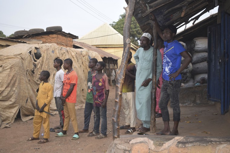 People gather around an area were gunmen kidnapped school children in Chikun, Nigeria