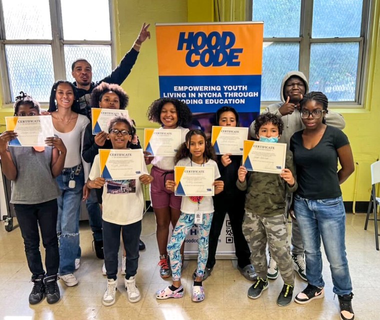 Jason Gibson, back left, stands with Hood Code students as they receive their participation certificate.