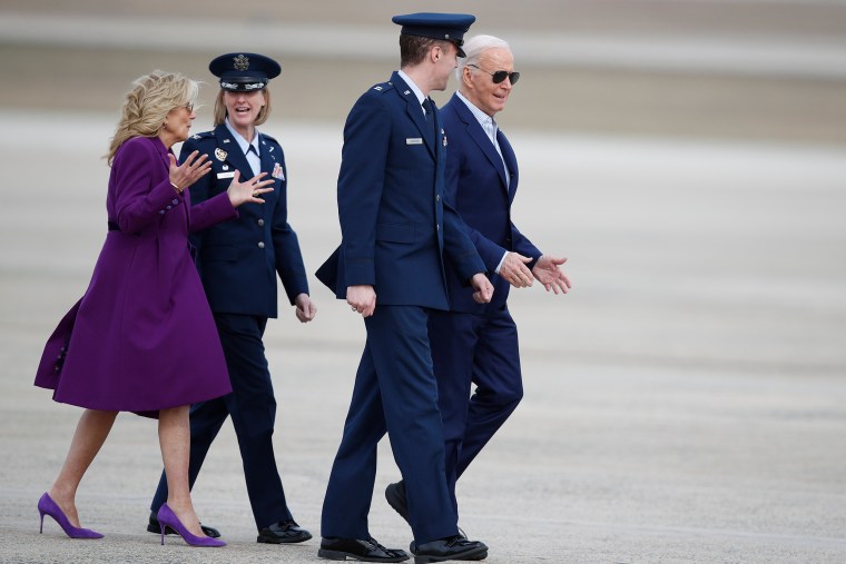 President Joe Biden, right, is escorted by Air Force Cpt. Eric Anderson, 89th Airlift Wing Flightline protocol officer, as first lady Jill Biden, left, talks to Col. Angela Ochoa, commander of the 89th Airlift Wing,