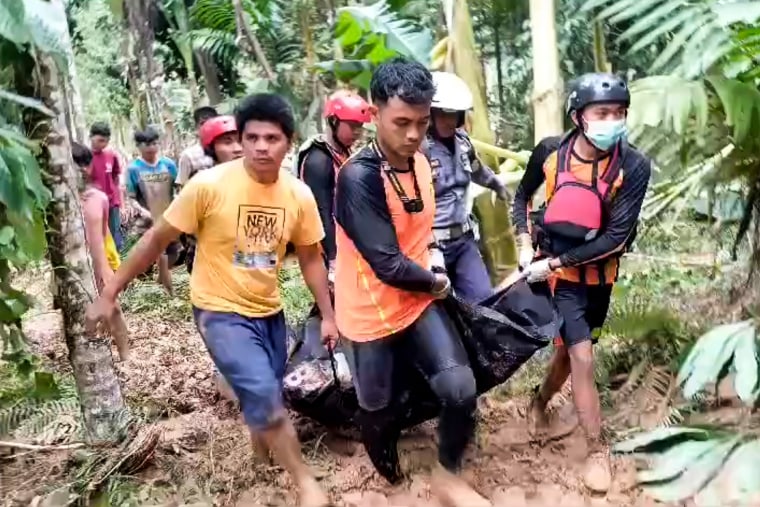 Rescuers carry the body of a victim of a flash flood
