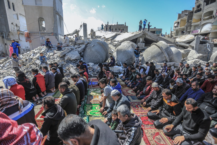 Palestinians perform Friday prayers around the ruins of Al-Farouq Mosque