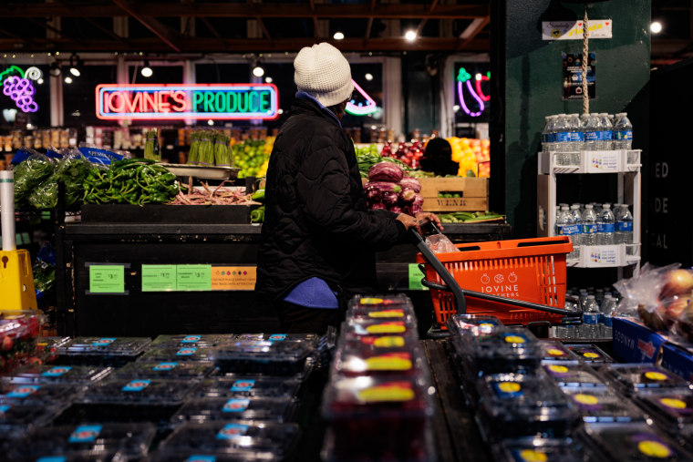 A shopper pushes a cart in the produce section of Reading Terminal Market.
