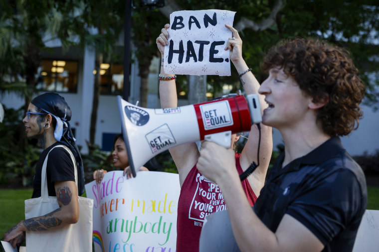 A demonstrator holds a placard reading "Ban Hate" during a 'Walkout 2 Learn' rally