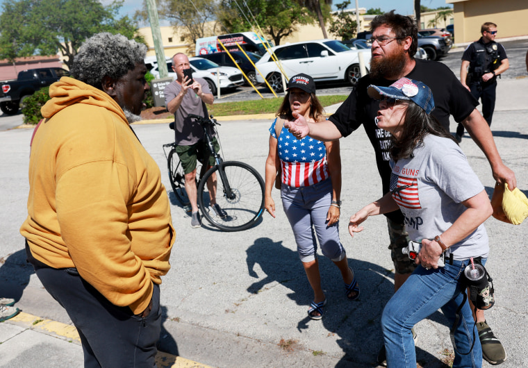 A supporter of President Joe Biden faces supporters of Donald Trump outside of the courthouse in Fort Pierce, Fla., where Trump attended a hearing in his classified records case on March 14.