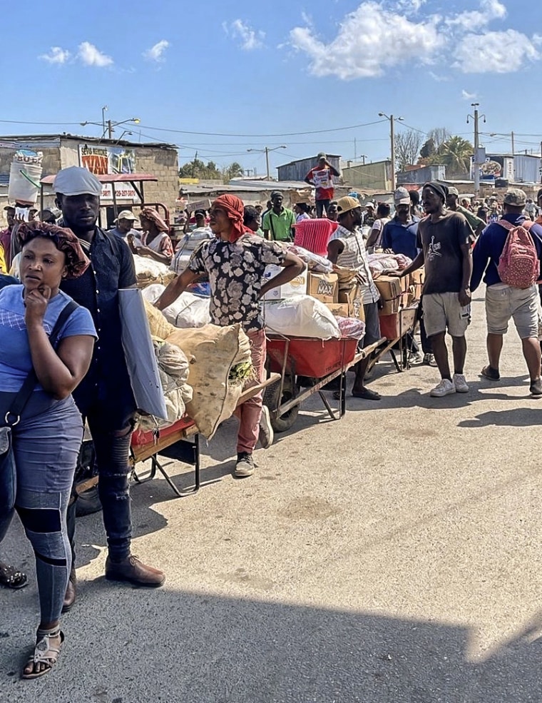 Haitians allowed into a farmer’s market in the border town of Dajabón Thursday return with food.