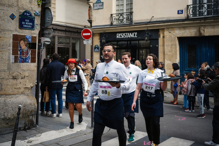 Waiters and waitresses compete in a traditionnal "Course des cafes" (the cafes' race), in central Paris, on March 24, 2024. 