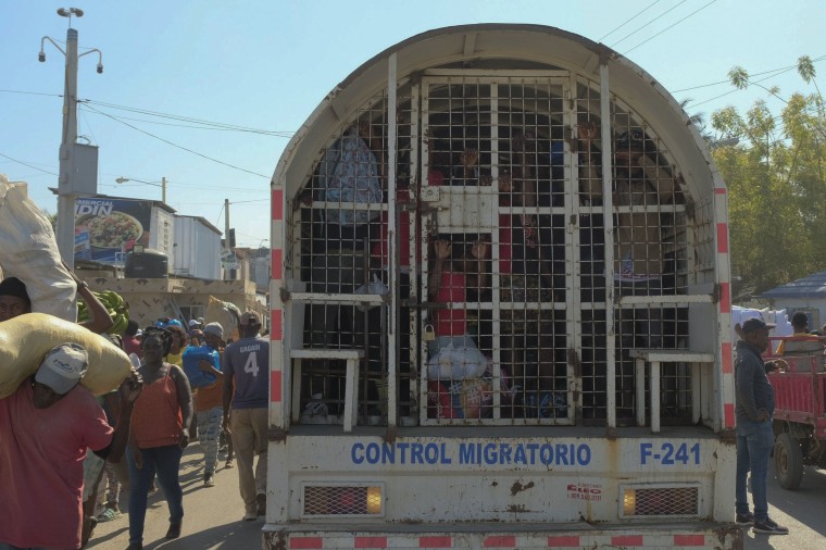 People who were detained for deportation to Haiti stand inside a police truck on the border bridge that connects Dajabon, Dominican Republic with Haiti on March 18, 2024.