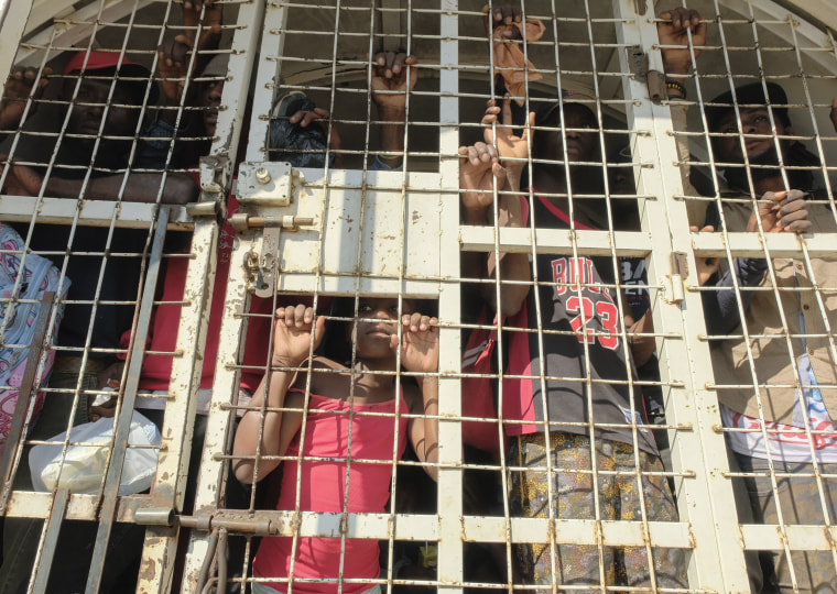 People who were detained for deportation to Haiti stand inside a police truck on the border bridge that connects Dajabon, Dominican Republic with Haiti on March 18, 2024.