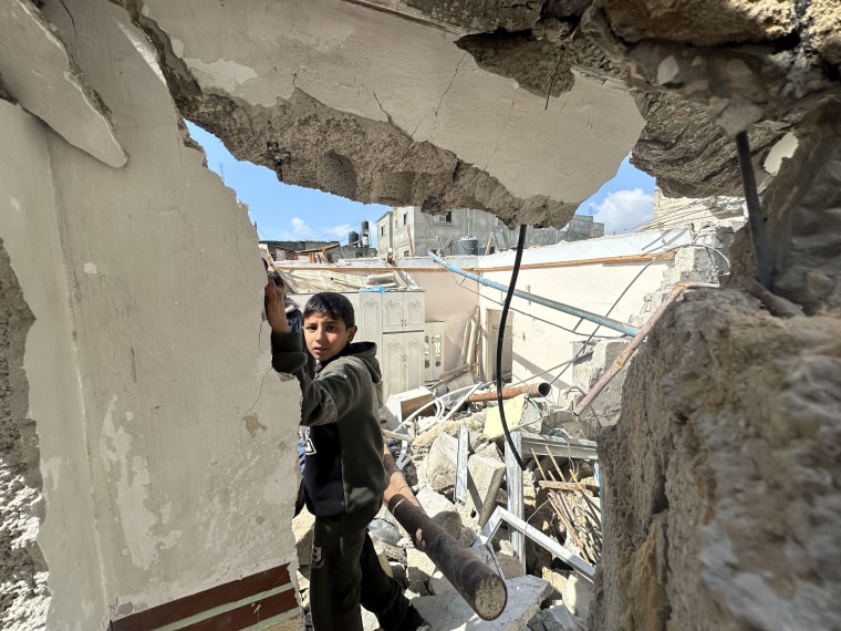 Palestinians, including children, collect remaining belongings from the rubble of destroyed houses and examine the rubble of collapsed buildings after Israeli warplanes hit on the house belonging to the Cargun family while the Israeli army's attacks on the blockaded Gaza Strip have continued uninterruptedly for 165 days in Rafah, Gaza on March 19, 2024. 