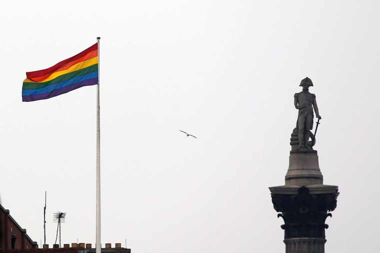 The rainbow flag, a symbol of the LGBTQ+ community, flies over a building next to Nelson's Column monument, right, in Trafalgar Square, central London in 2014