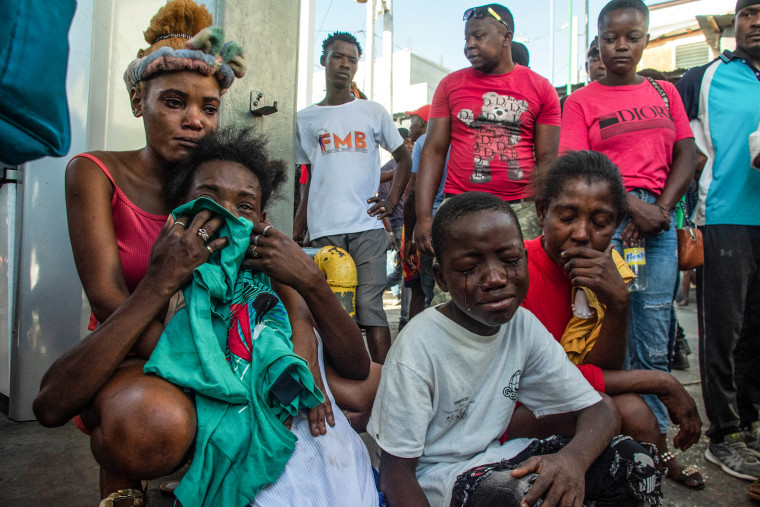 Image: People react after a dozen of people were killed in the street by gang members, in Pétion-Ville, Port-au-Prince, Haiti