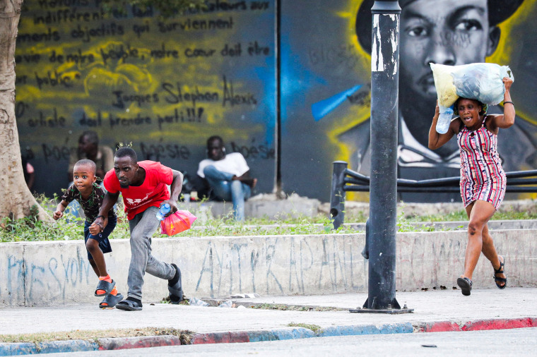 People take cover from gunfire.