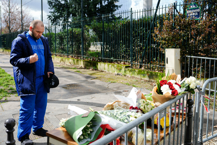 A man pays tribute at a makeshift memorial in front of Russia's Embassy in Paris