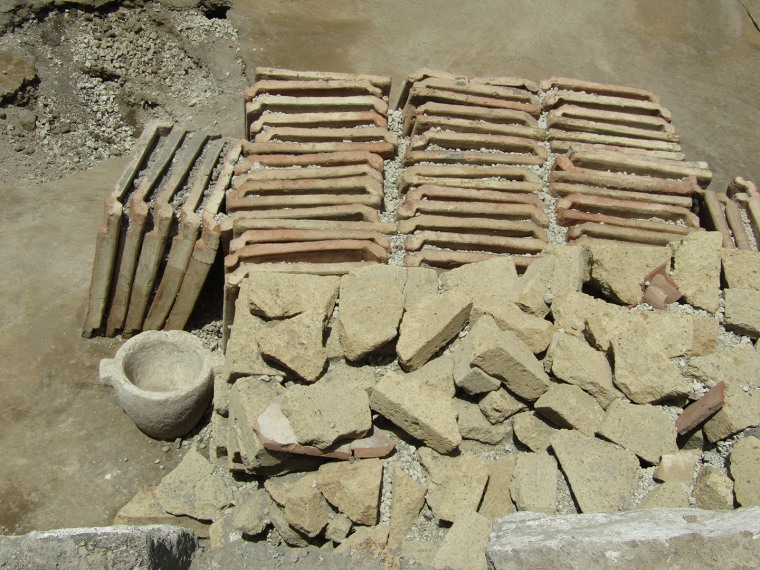 The archaeologists found working tools, stacked roof tiles, tuff bricks, and heaps of lime and stones used to create walls.                      