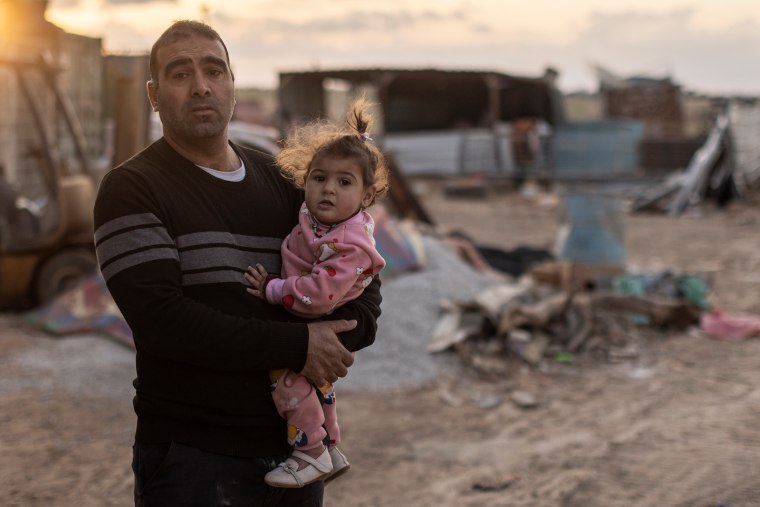 Muhammad Abu Qwaider holding his daughter, Maisa.