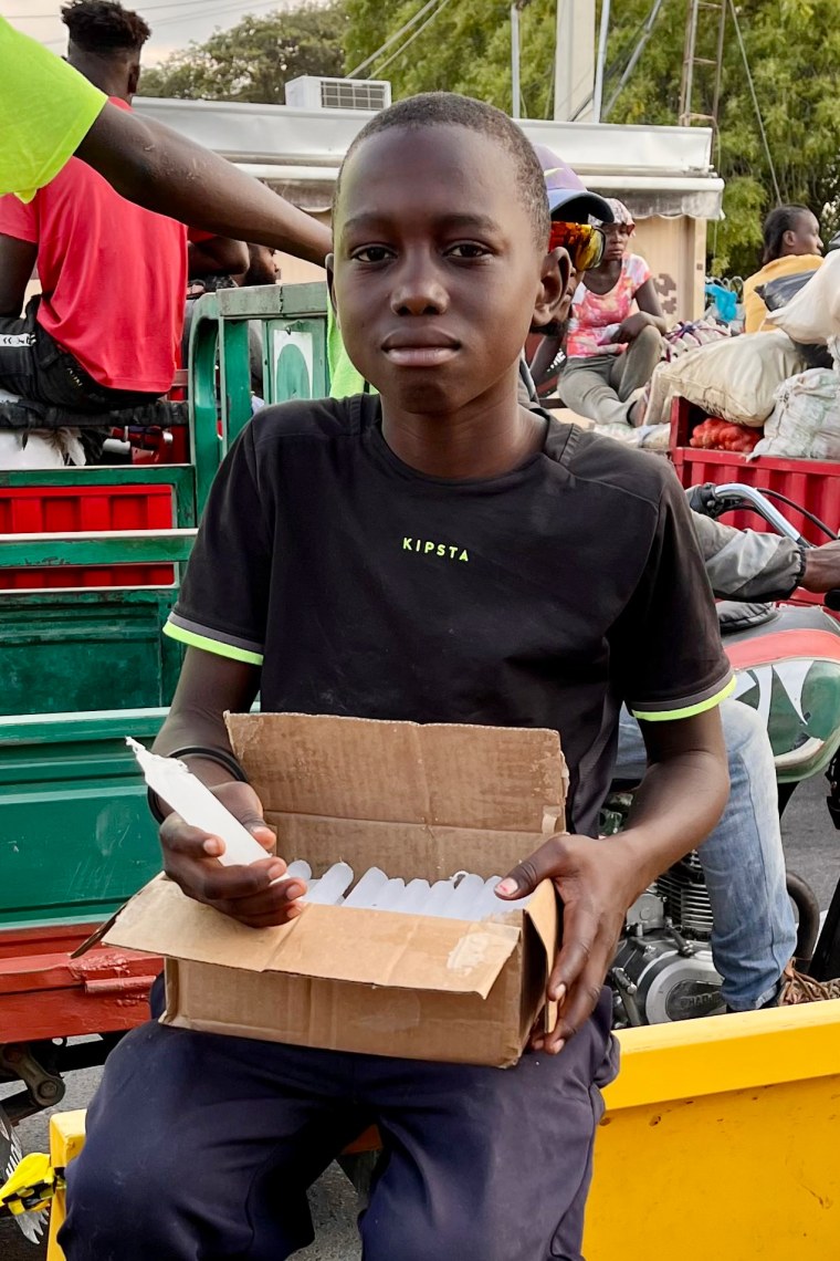 Kelvin Vensy holds a box of candles in the street.
