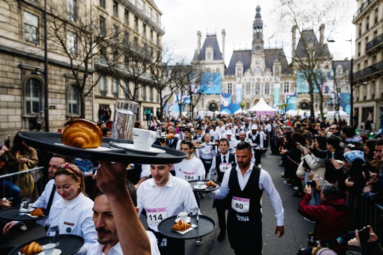 Around 200 participants gathered to compete in the 2km race around Paris' Marais district single-handedly carrying a tray bearing a coffee, a glass of water and a croissant. Founded in 1914, this is the first edition of the race after a 13-year hiatus. (Photo by Dimitar DILKOFF / AFP) (Photo by DIMITAR DILKOFF/AFP via Getty Images)