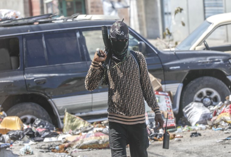 An armed member of the G9 and Family gang patrols a roadblock in of Port-au-Prince, Haiti