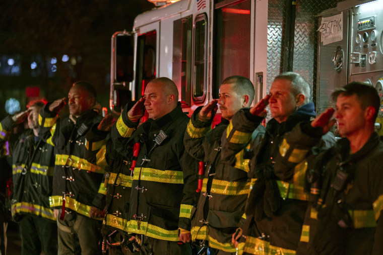 Firefighters salute as the ambulance transporting the body of New York City Police Officer Jonathan Diller exits Jamaica Hospital Medical Center in Queens on March 25, 2024.