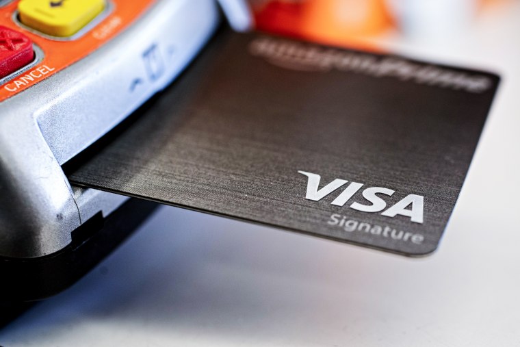 A Visa credit card is inserted into a card reader