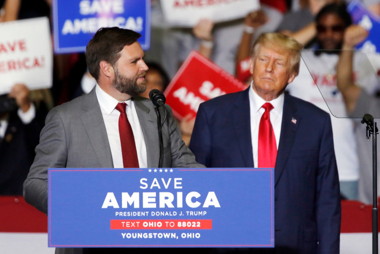 Donald Trump looks at JD Vance at a campaign rally.