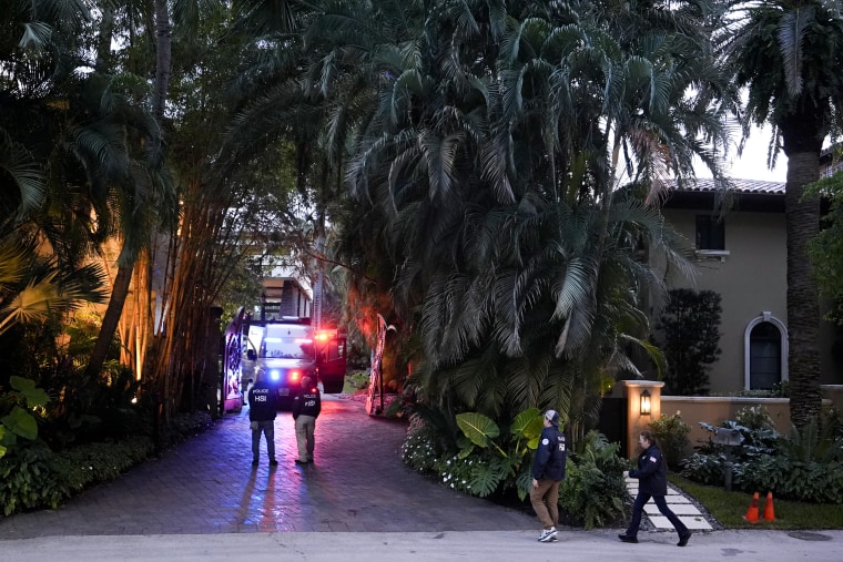 Federal agents walk at the entrance to a property belonging to Sean "Diddy" Combs 