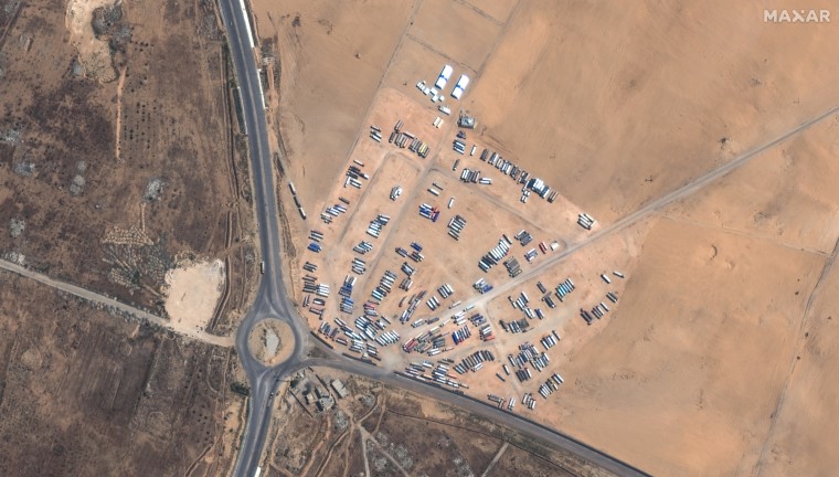 A satellite image from March 21 shows lines of trucks on the road and parked in a lot near the Rafah crossing.
