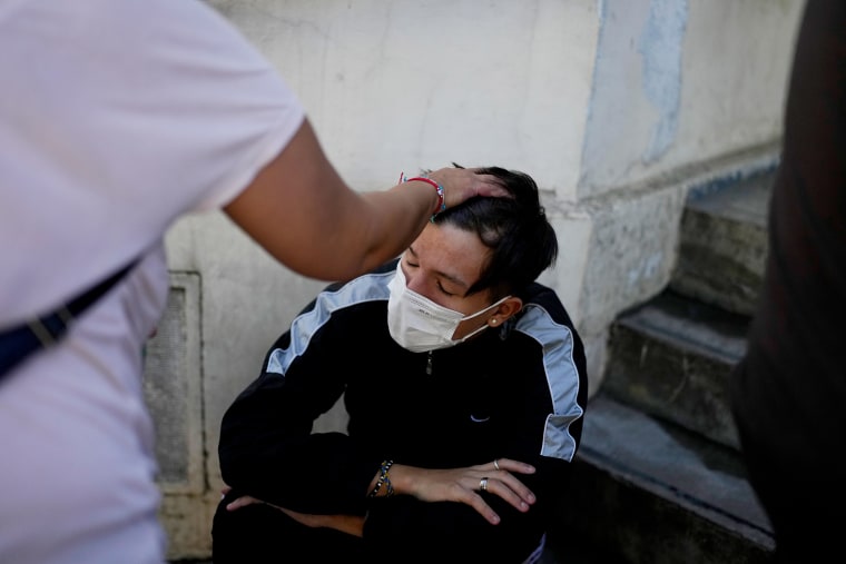 A man sits while waiting to be attended at a hospital.