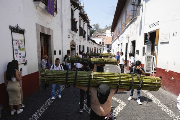 Penitents carry a bundle of thorny branches during a Holy Week procession in Taxco, Mexico, Thursday, March 28, 2024. 