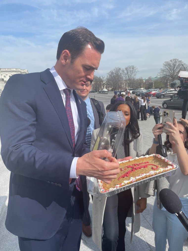 Rep. Mike Gallagher, R-Wis., celebrates with a cookie cake after his bill to ban TikTok passed the House.