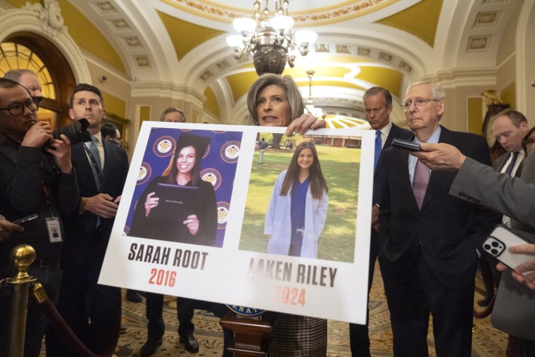 La senadora Joni Ernst, republicana por Iowa, sostiene un cartel con la foto de la estudiante Laken Riley, asesinada en Georgia.