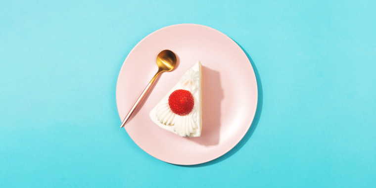 strawberry cheesecake on the pink plate on blue background. Flat-lay, top view.