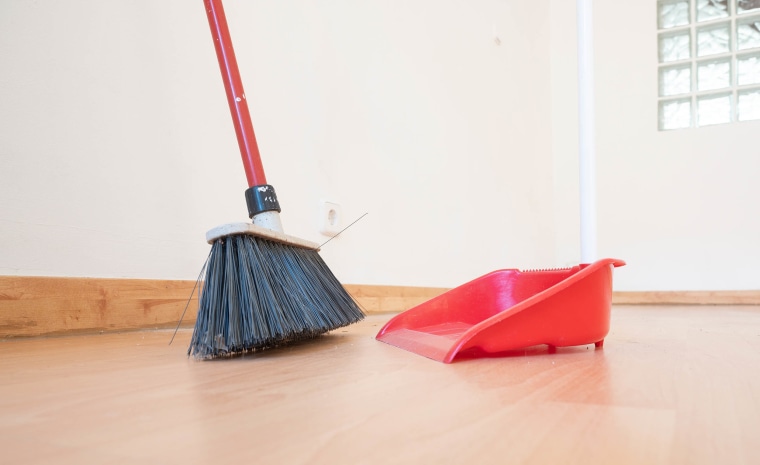 A broom and dustpan in an empty room. Moving concept
