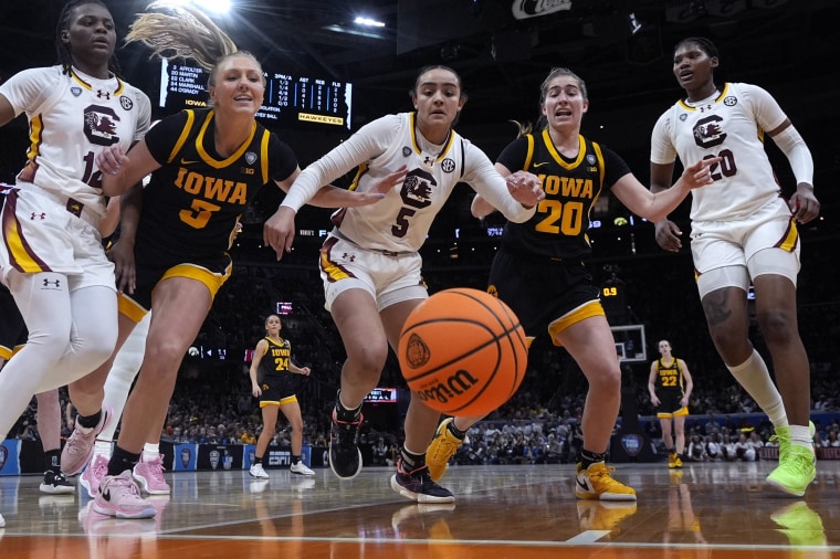 South Carolina guard Tessa Johnson (5) fights for a loose ball with Iowa guard Sydney Affolter (3) and guard Kate Martin (20) during the second half on Sunday.