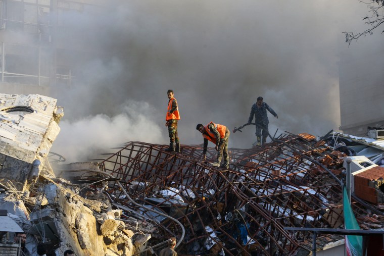 Emergency personnel extinguish a fire at the site of strikes which hit a building next to the Iranian embassy in Syria's capital Damascus, on April 1, 2024.