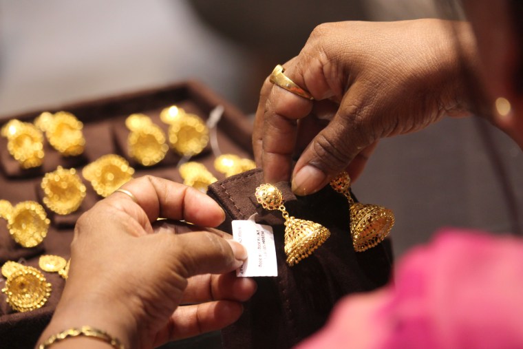 A customer holds gold jewelry in Mumbai, India