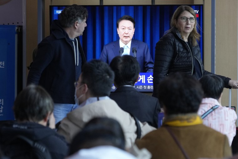 People watch a TV screen showing the live broadcast of South Korean President Yoon Suk Yeol’s addressing the nation at the Seoul Railway Station in Seoul, South Korea, Monday, April 1, 2024. 