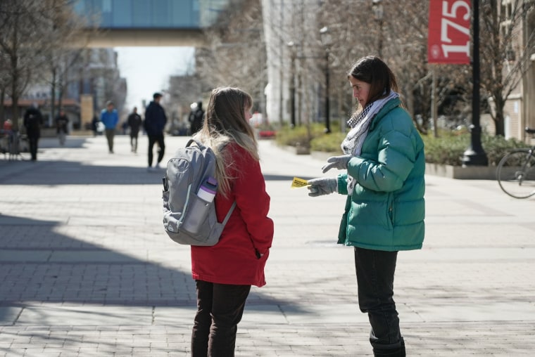 Dahlia Saba, a student activist, passes out flyers on campus