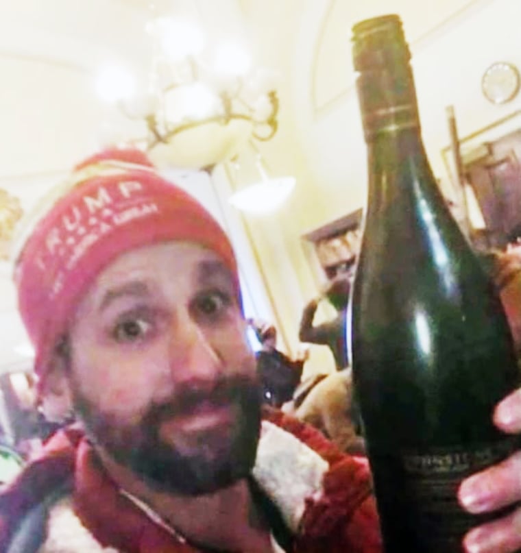 Jason Riddle holds a bottle of wine inside the Capitol.