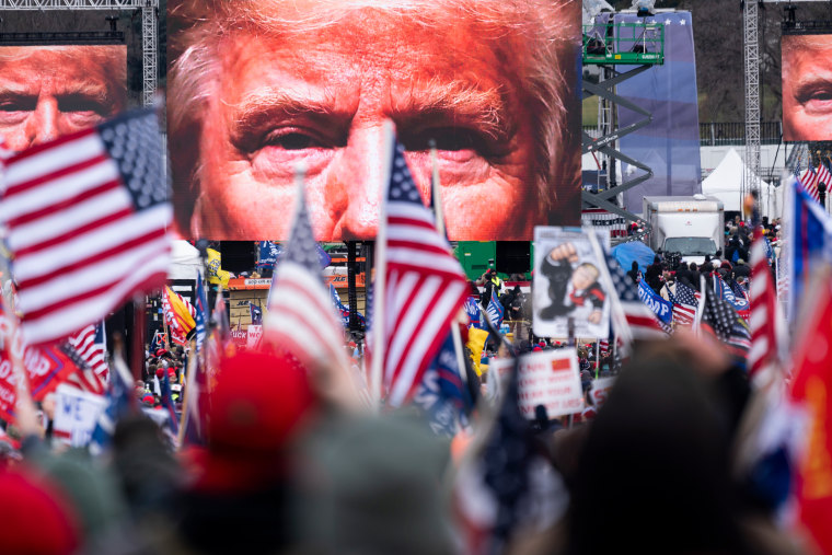 An image of President Donald Trump appears on video screens
