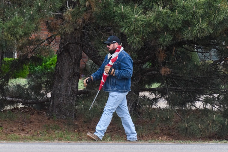 Judd Blevins walks with a rolled-up flag.