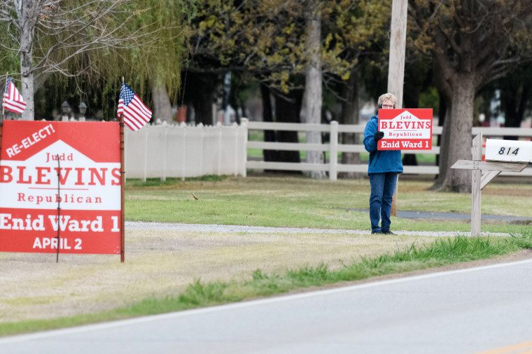 A Judd Blevins supporter waves a sign to passing cars.