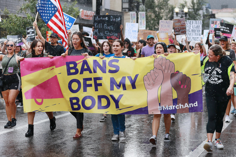 Demonstrators march in the rain during an abortion rights rally
