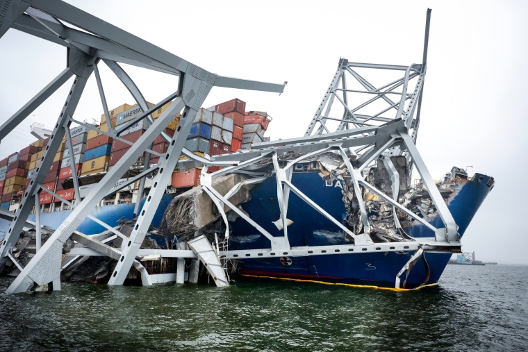 The wreckage of the Francis Scott Key Bridge remains twisted around the front of the cargo ship Dali