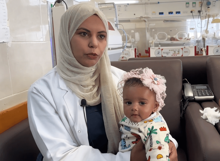 Baby Malak with her de-facto guardian, Dr. Amal Abu Khatleh, at the Emirati Hospital in Rafah in southern Gaza. 