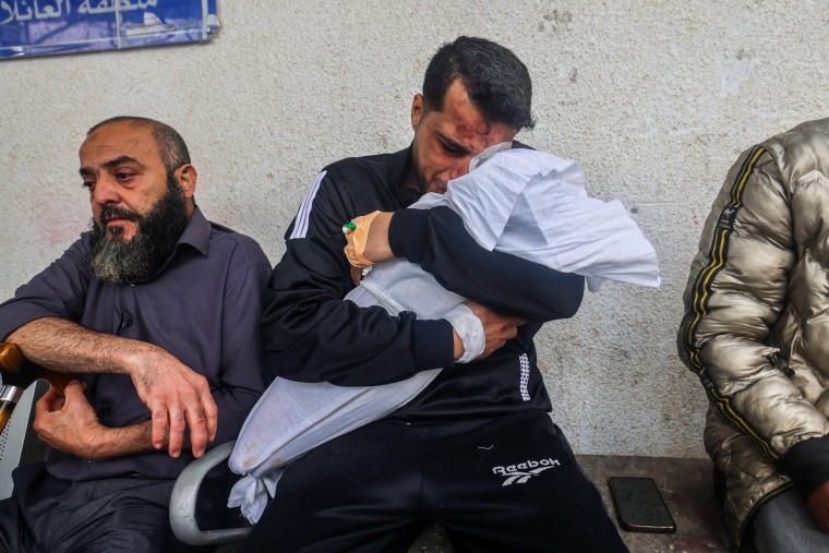 Palestinian father Ashraf cries as he holds the body of one of his two daughters after they were both killed in an overnight strike in Rafah, southern Gaza Strip, on April 4, 2024.