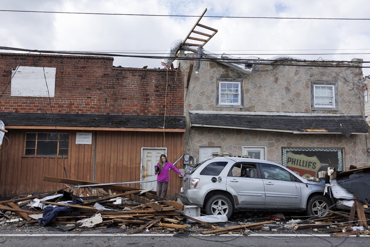 A woman exits a tornado damaged building on April 3, 2024 in Sunbright, Tenn.