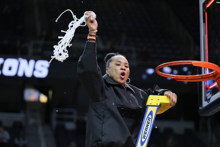 Head coach Dawn Staley of the South Carolina Gamecocks cuts down the net after beating the Oregon State Beavers in Albany, N.Y.